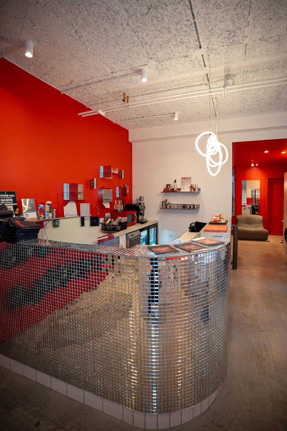 Le comptoir d’accueil de Beat 35, devant un mur orange